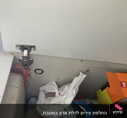 ציר מתכת מותקן על דלת ארון עץ